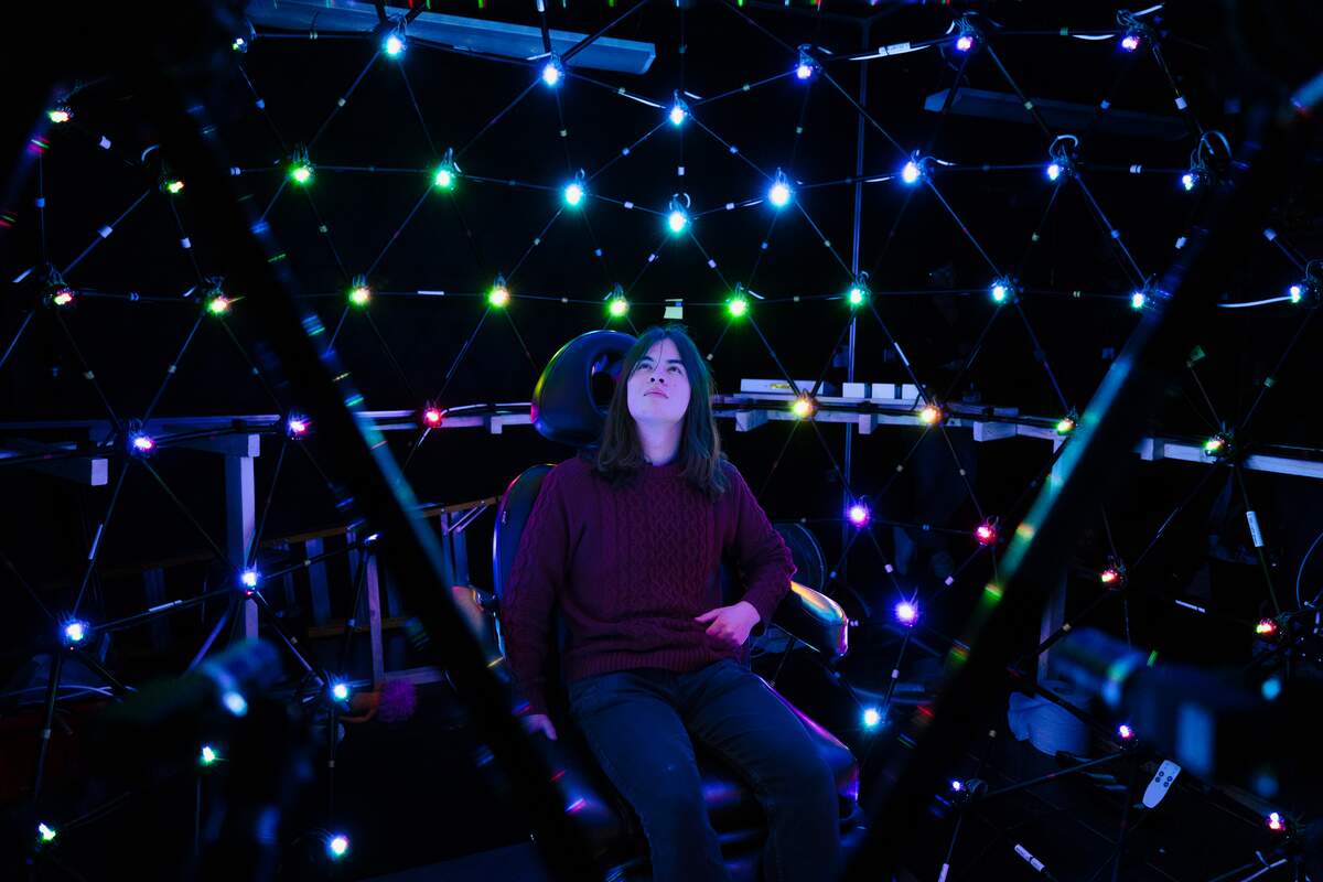 a student sitting in the lightstage in the computer science building